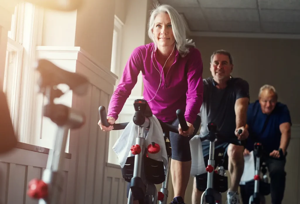 Clase de spinning en gimnasio con entrenamiento en grupo y ambiente energico