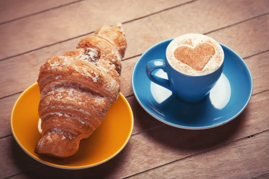 Café y croissant en una cafetería con ambiente musical cuidado