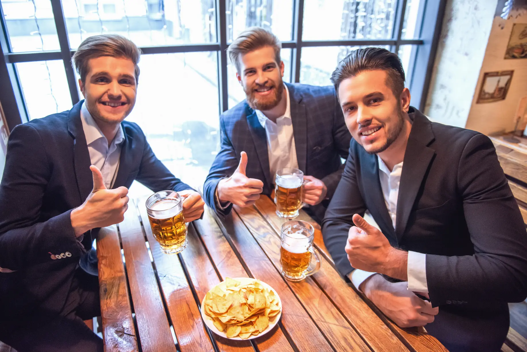 Clientes viendo un partido de fútbol en un pub con música ambiental